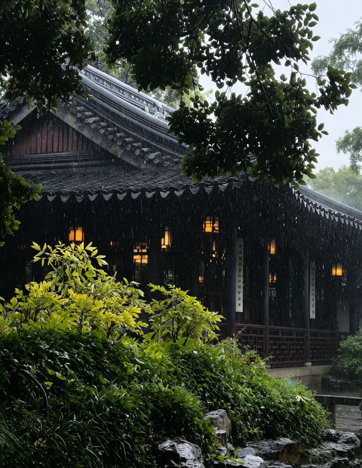 雨中绿树掩映的传统庭院、灰瓦屋檐与温暖窗灯