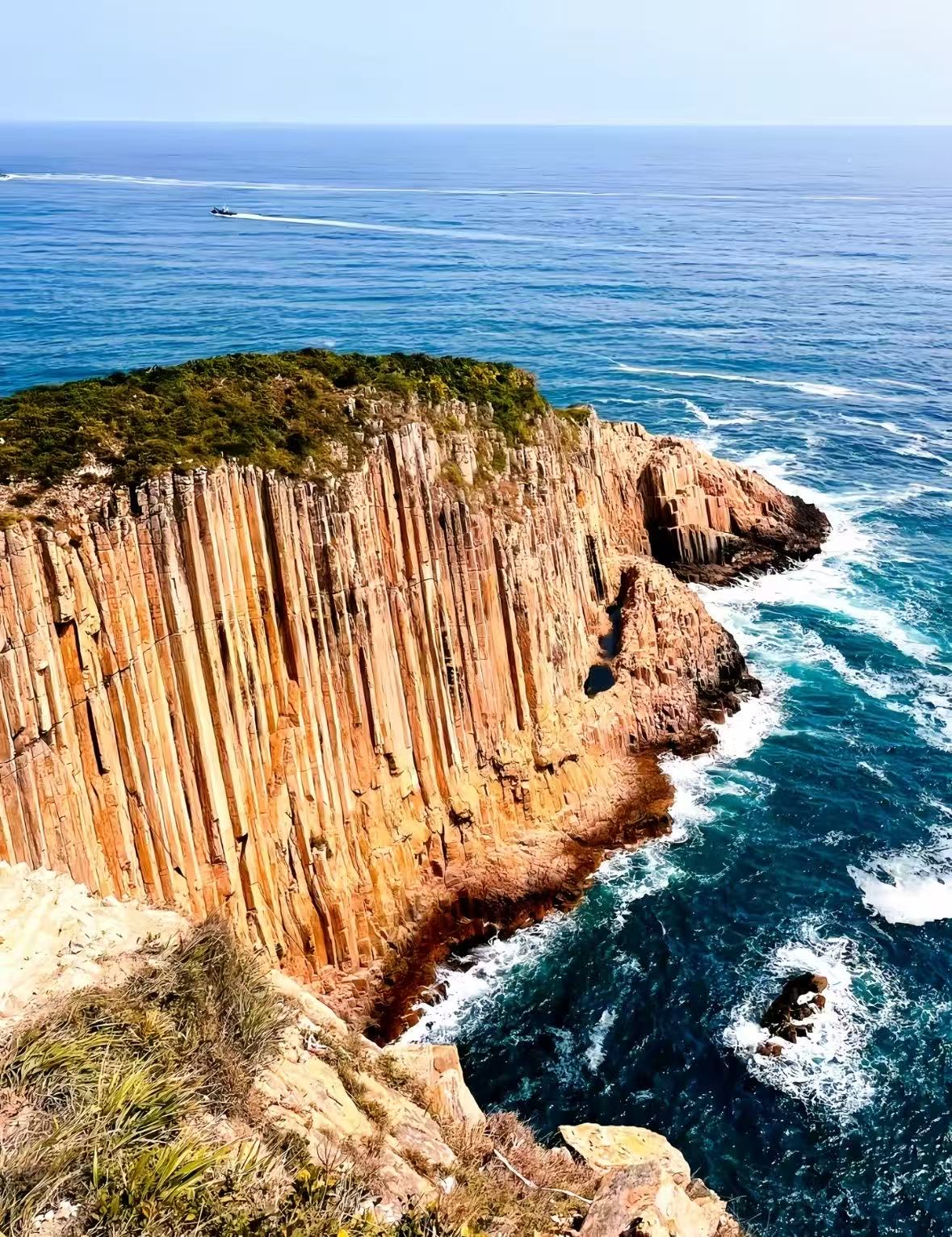 蓝色海水与高耸的柱状海岸岩壁